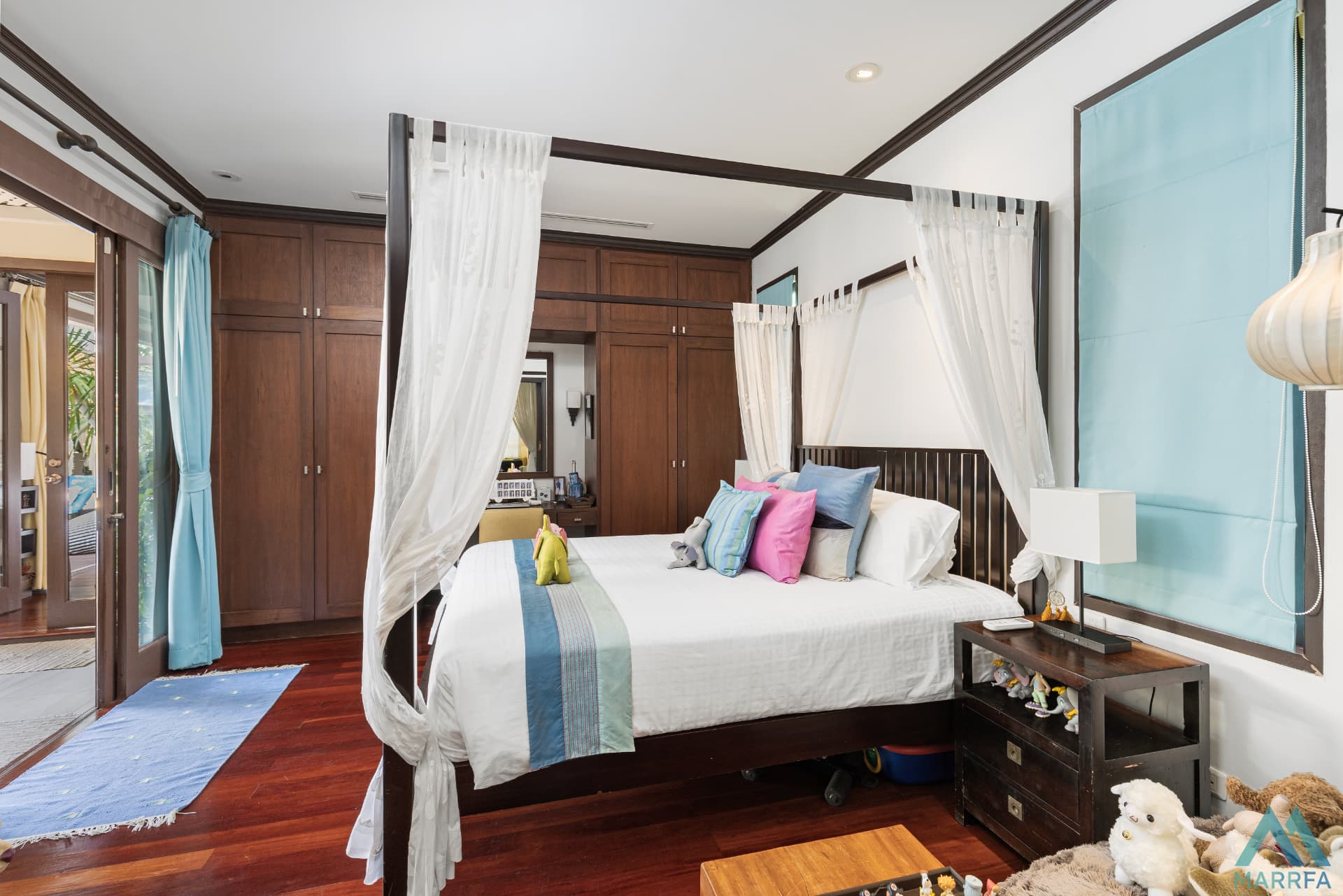 Bedroom with four-poster bed and built-in teak wardrobes